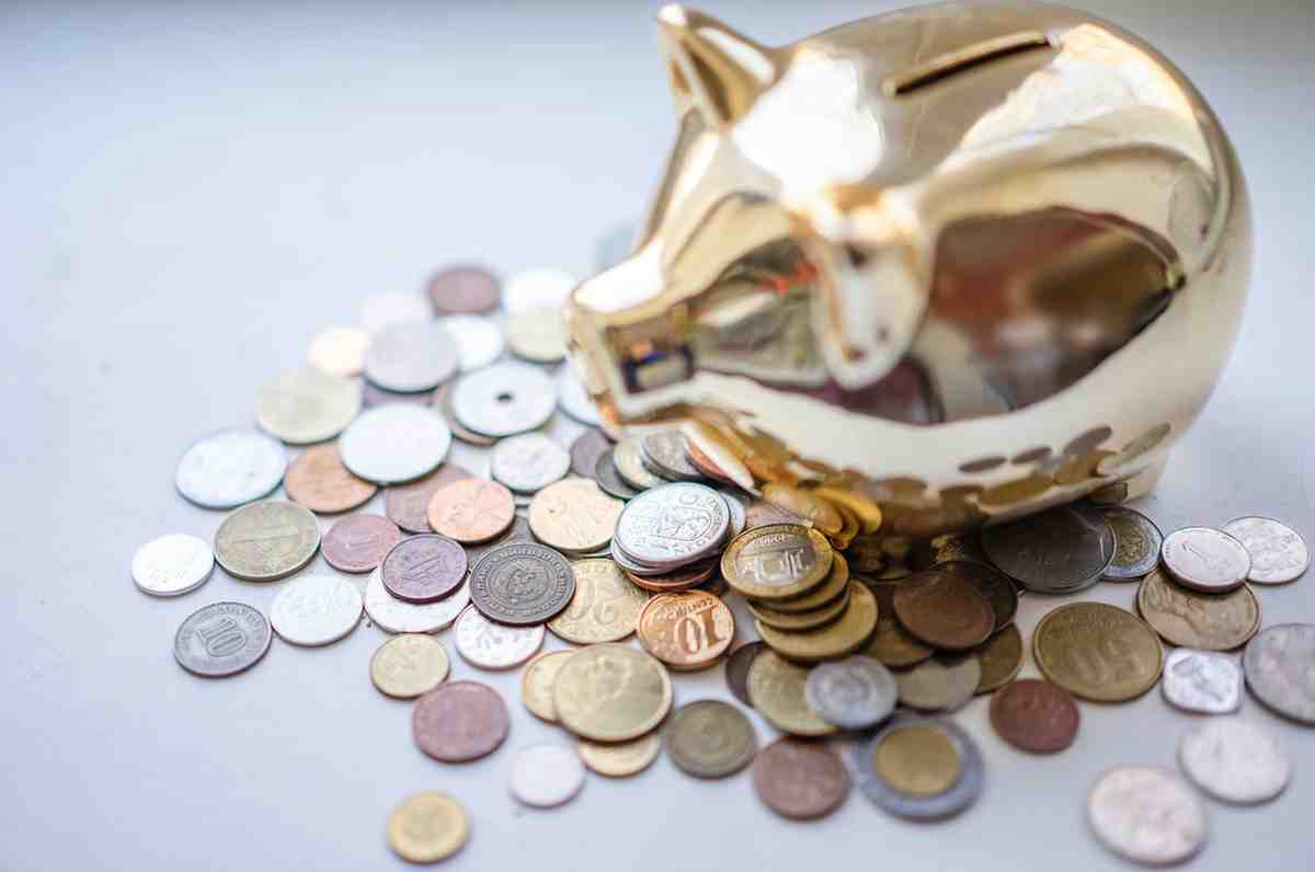 Glass savings jar with coins and growing plant representing disciplined personal budgeting success.