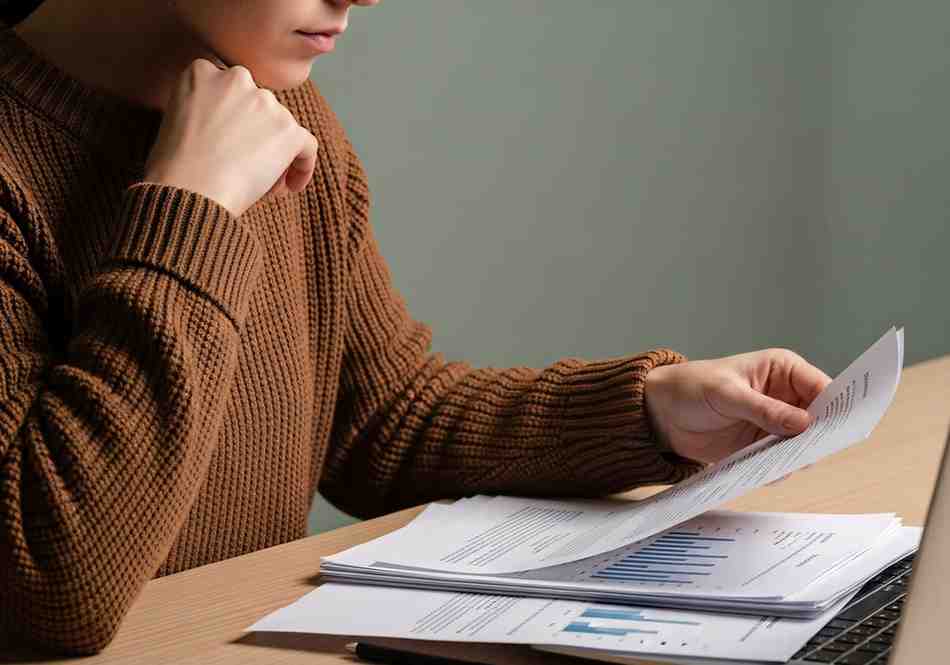 Focused professional analyzing personal budget cash flow and expense spreadsheets at desk.